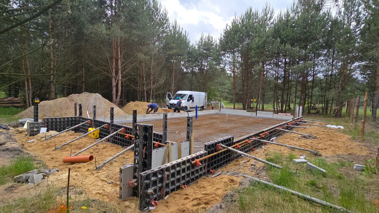 Szalunek systemowy na obwodzie płyty fundamentowej na działce wśród drzew